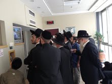 As the news spread, the crowd began to cluster around the TV for confirmation (Photo credit: Mitch Ginsburg/ Times of Israel)