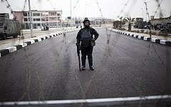 A riot policeman stands guard behind barbed wire outside of a police academy compound were the trial of ousted President Mohammed Morsi will be held in Cairo, Egypt, Monday, Nov. 4, 2013. (photo credit: AP Photo/Manu Brabo)