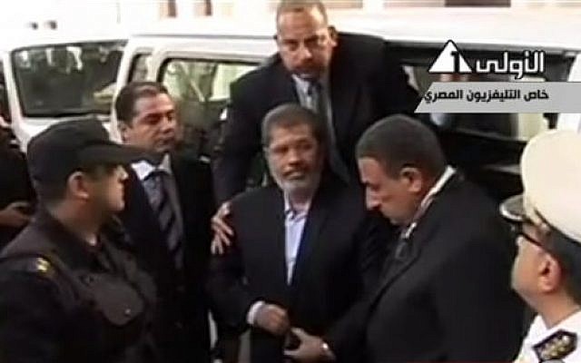 This image made from video broadcast on Egyptian State Television shows ousted President Mohammed Morsi arriving for a court hearing at a police academy compound in Cairo, Egypt, Monday, Nov. 4, 2013. (photo credit: AP Photo/Egyptian State Television via AP video) This image made from video broadcast on Egyptian State Television shows ousted President Mohammed Morsi arriving for a court hearing at a police academy compound in Cairo, Egypt, Monday, Nov. 4, 2013. (photo credit: AP Photo/Egyptian State Television via AP video)