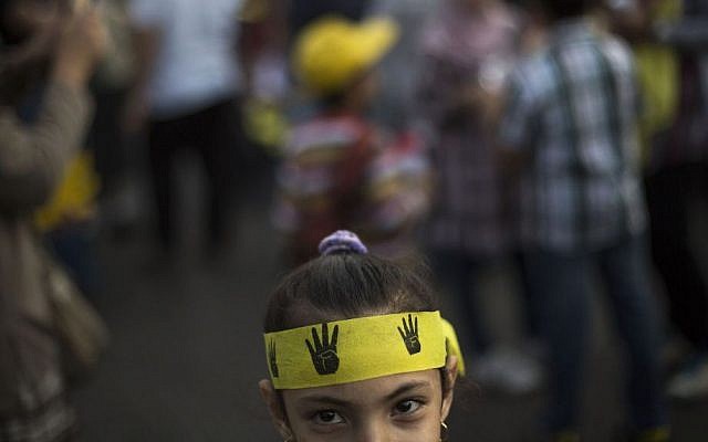 An Egyptian girl attends a protest by supporters of Egypt's ousted president Mohammed Morsi, in Nasr City in Cairo, Egypt, Friday Nov. 1, 2013. Her headband bears the four-fingered emblem which has become a symbol of the Rabiah al-Adawiya mosque, where Morsi supporters held a sit-in for weeks that was violently dispersed in August. (AP Photo/Manu Brabo) An Egyptian girl attends a protest by supporters of Egypt's ousted president Mohammed Morsi, in Nasr City in Cairo, Egypt, Friday Nov. 1, 2013. Her headband bears the four-fingered emblem which has become a symbol of the Rabiah al-Adawiya mosque, where Morsi supporters held a sit-in for weeks that was violently dispersed in August. (AP Photo/Manu Brabo)