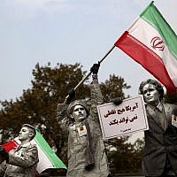 Iranian artists hold posters with Persian that reads,'"America cannot do a damn thing,' as they perform during an annual anti-American demonstration in Tehran, Iran, Monday, Nov. 4, 2013 (photo credit: AP/Ebrahim Noroozi) Iranian artists hold posters with Persian that reads,'"America cannot do a damn thing,' as they perform during an annual anti-American demonstration in Tehran, Iran, Monday, Nov. 4, 2013 (photo credit: AP/Ebrahim Noroozi)