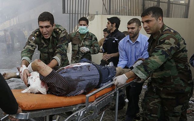 Lebanese army soldiers help an injured man at the scene where two explosions have struck near the Iranian Embassy on Tuesday, Nov. 19, 2013. (photo credit: AP/Hussein Malla) Lebanese army soldiers help an injured man at the scene where two explosions have struck near the Iranian Embassy on Tuesday, Nov. 19, 2013. (photo credit: AP/Hussein Malla)