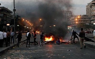 Protesters throw rocks at supporters of the Muslim Brotherhood in the Nasr City district in Cairo, Egypt, Friday, Nov. 22, 2013 (photo credit: AP/El-Shorouk newspaper, Sabry Khaled)