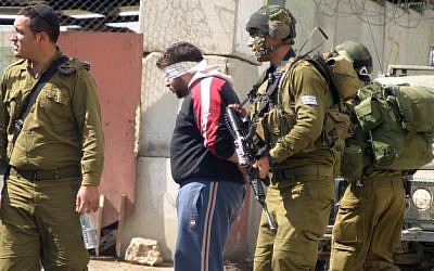 Illustrative photo of Israeli soldiers blindfolding and detaining Palestinians. (Najeh Hashlamoun/Flash90)