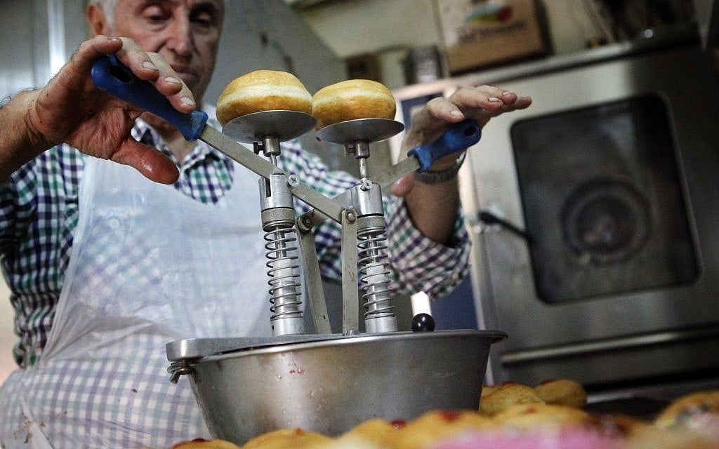 Filling the doughnuts at Jerusalem's Pe'er Bakery (photo credit: Miriam Alster/Flash 90) Filling the doughnuts at Jerusalem's Pe'er Bakery (photo credit: Miriam Alster/Flash 90)
