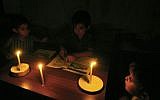 Palestinian children do their homework by candlelight in their family home, during a power cut in the Rafah refugee camp in the southern Gaza Strip, on September 18, 2013. (Abed Rahim Khatib/Flash90)
