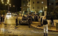 Bomb squad police unit examine the blackened remains of a car that exploded in a suspected bombing in the southern city of Ashkelon, Saturday night, November 2, 2013. (photo credit: David Buimovitch/Flash90)