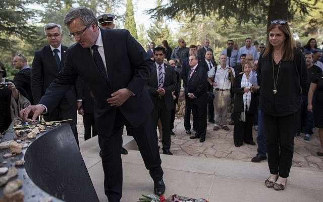 Poland's visiting President Bronislaw Komorowski puts a stone on the  grave of prime minister grave Yitzhak Rabin during a ceremony marking the 18th anniversary of his assassination, at Mount Herzl cemetery in Jerusalem, on November 4, 2013. (Photo credit: Yonatan Sindel/Flash 90)