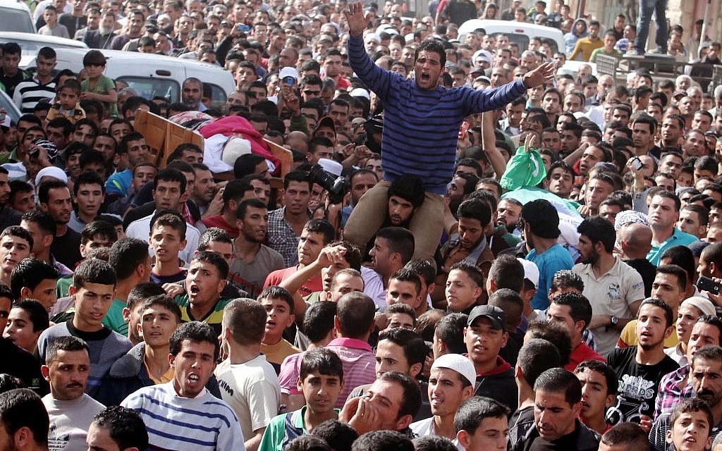 Mourners attend the funeral of Palestinian militants Khaled al-Najjar and Mussa Fanasheh on Wednesday November 27, 2013 in the West Bank village of Yatta, near Hebron, one day after they were shot dead by Israeli forces. (Photo credit: Issam Rimawi/Flash90)