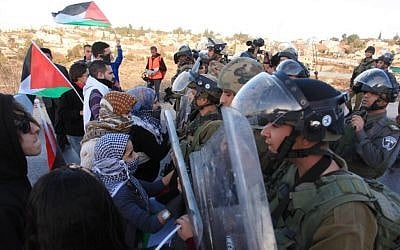Israeli soldiers clash with Palestinian protesters outside the Jewish settlement of Beit El, near the West Bank city of Ramallah, during a demonstration against the Israeli government's plan to resettle some 30,000 Bedouin residents of the Negev desert. The demonstrations were organized as part of an International Day of Rage against the Law for Arranging Bedouin Settlement in the Negev, known as the Prawer-Begin Plan. November 30, 2013. (Photo credit: Issam RImawi/ FLASH90)