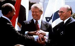 Egyptian President Anwar Sadat, left, US President Jimmy Carter, center, and Prime Minister Menachem Begin clasp hands on the North Lawn of the White House after signing the peace treaty between Egypt and Israel, March 26, 1979 (photo credit: AP/Bob Daugherty/File)