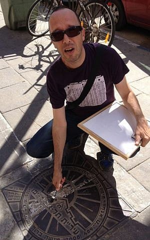 Guy Sharett finds a Hebrew lesson wherever he goes, even on manholes (photo credit: Jessica Steinberg/Times of Israel)