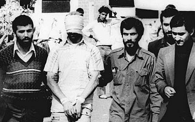 One of the hostages being held at the US Embassy in Tehran is displayed to the crowd, blindfolded and with his hands bound, outside the embassy in 1979 (photo credit: AP Photo/File)
