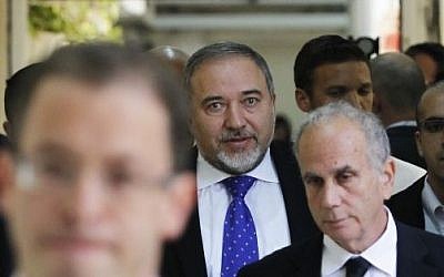 Former foreign minister Avigdor Liberman, center, walks toward a courtroom at the Magistrate's Court in Jerusalem, Wednesday, November 6, 2013 (photo credit: AP/Ronen Zvulun, Pool)