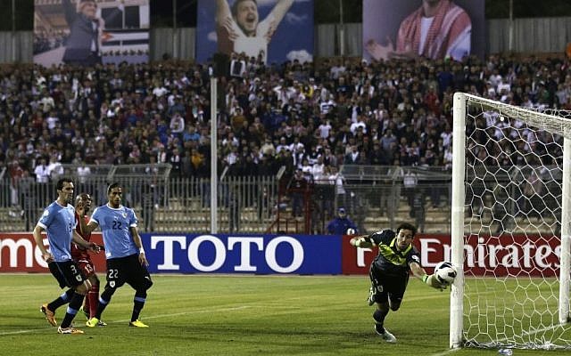 Uruguay's goalkeeper Martin Silva, right, saves a goal against Jordan during the World Cup play off first leg soccer match between Jordan and Uruguay at Amman International stadium in Amman, Jordan, on Wednesday, November 13, 2013. (photo credit: AP Photo/Hassan Ammar) Uruguay's goalkeeper Martin Silva, right, saves a goal against Jordan during the World Cup play off first leg soccer match between Jordan and Uruguay at Amman International stadium in Amman, Jordan, on Wednesday, November 13, 2013. (photo credit: AP Photo/Hassan Ammar)