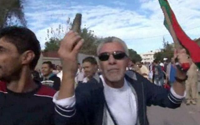 This image made from video shows a protester holding up spent ammunition in Tripoli, Libya after militiamen attacked peaceful protesters demanding the disbanding of the country's rampant armed groups on Friday, Nov. 15, 2013, killing tens of people as they opened fire on the march with heavy machine guns and rocket-propelled grenades. (AP Photo via AP video) This image made from video shows a protester holding up spent ammunition in Tripoli, Libya after militiamen attacked peaceful protesters demanding the disbanding of the country's rampant armed groups on Friday, Nov. 15, 2013, killing tens of people as they opened fire on the march with heavy machine guns and rocket-propelled grenades. (AP Photo via AP video)