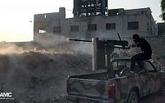 A Syrian rebel fires a weapon towards Syrian government troops loyal to President Bashar Assad in, Syria., Saturday, Nov. 9, 2013. (photo credit: AP/Aleppo Media Center AMC, File)