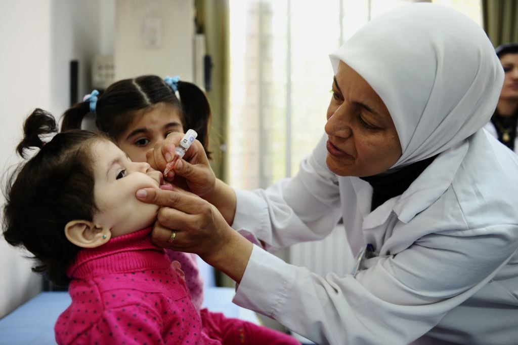 A health worker administers polio vaccine to a child as part of a UNICEF-supported vaccination campaign at the Abou Dhar Al Ghifari Primary Health Care Center in Damascus, Syria. (photo credit: AP/UNICEF, Omar Sanadiki) A health worker administers polio vaccine to a child as part of a UNICEF-supported vaccination campaign at the Abou Dhar Al Ghifari Primary Health Care Center in Damascus, Syria. (photo credit: AP/UNICEF, Omar Sanadiki)