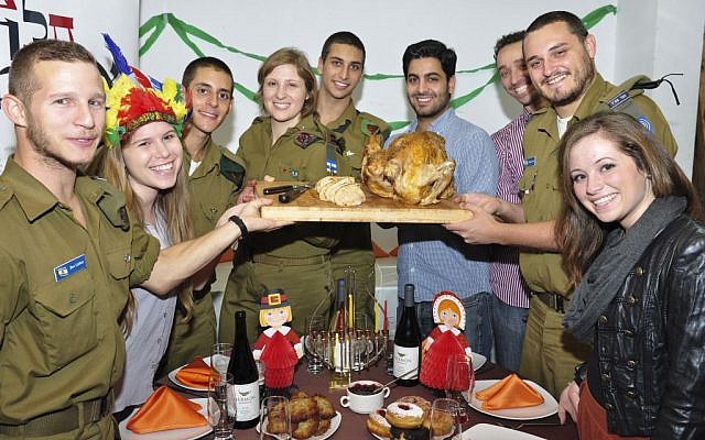 Lone soldiers and young professionals gathered around a turkey at the Nefesh B'Nefesh/White City Shabbat meal in Tel Aviv in November. (photo Credit: Studio Tel/Courtesy of Nefesh B’Nefesh)