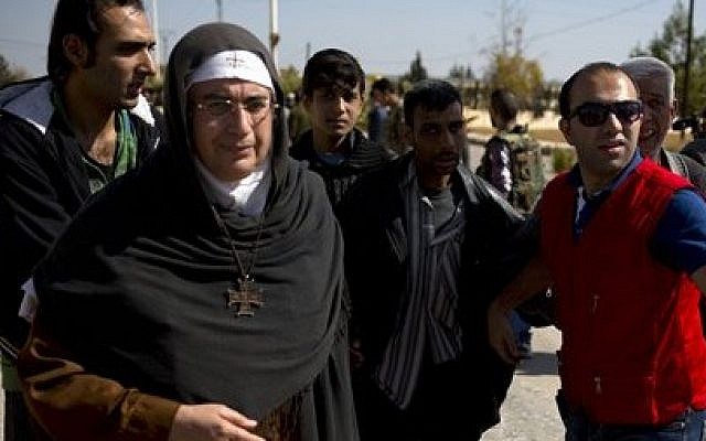 Mother Superior Agnes-Mariam Of The Cross walks with people fleeing the rebel held suburb of Moadamiyeh to the government held territory in Damascus, Syria, Oct. 29, 2013 (photo credit: AP/Dusan Vranic)