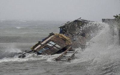 A house is engulfed by the storm surge brought about by powerful typhoon Haiyan that hit Legazpi city, Albay province Friday, about 520 kilometers south of Manila, Philippines. Typhoon Haiyan, one of the most powerful typhoons ever recorded slammed into the Philippines on Friday, setting off landslides, knocking out power in one entire province and cutting communications in the country's central region of island provinces. (AP Photo/Nelson Salting)