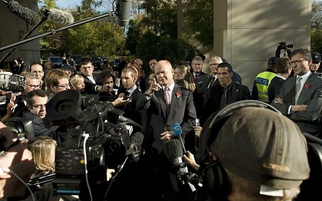 British Foreign Secretary William Hague, center, speaks to journalists during the third days of closed-door nuclear talks with Iran at the United Nations offices in Geneva Switzerland, Saturday. (AP Photo/Keystone,Martial Trezzini)