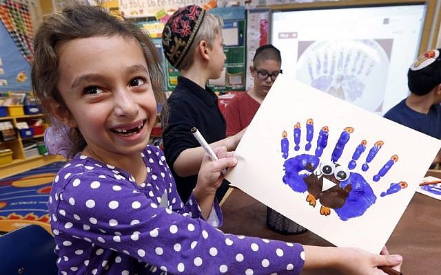 Second-grader Rozie Aronov, 7, holds up a menurkey, a paper-and-paint mashup of a menorah and turkey she created at Hillel Day School in Farmington Hills, Mich., Wednesday, Nov. 20, 2013. (photo credit: AP/Paul Sancya) Second-grader Rozie Aronov, 7, holds up a menurkey, a paper-and-paint mashup of a menorah and turkey she created at Hillel Day School in Farmington Hills, Mich., Wednesday, Nov. 20, 2013. (photo credit: AP/Paul Sancya)