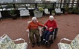 Holocaust survivors Joe Chaba, 85, and his wife, Helen, 89, sit together on the rooftop of the Selfhelp Home retirement community, in Chicago (photo credit: AP/M. Spencer Green/File)