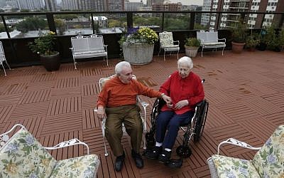 Holocaust survivors Joe Chaba, 85, and his wife, Helen, 89, sit together on the rooftop of the Selfhelp Home retirement community, in Chicago (photo credit: AP/M. Spencer Green/File)