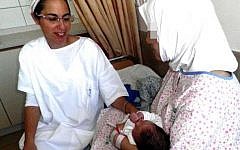 A Syrian woman cradles her newborn baby at a Safed hospital, Sunday, October 3, 2013 (photo credit: Twitter)