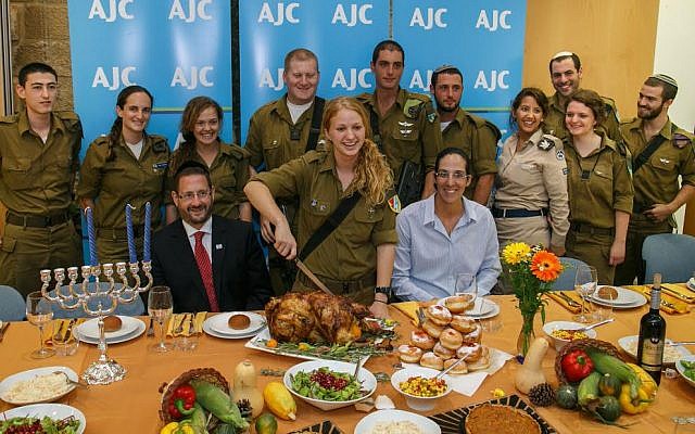 Lone soldiers including Galia Goldchain and Hannah Erdfarb with MK Dov Lipman and Paralympic athlete Moran Samuel during AJC's Thanksgiving and Hanukkah feast for lone soldiers on November 28, 2013 at the offices of AJC Jerusalem. (photo credit: Assaf Shilo/Israel Sun)