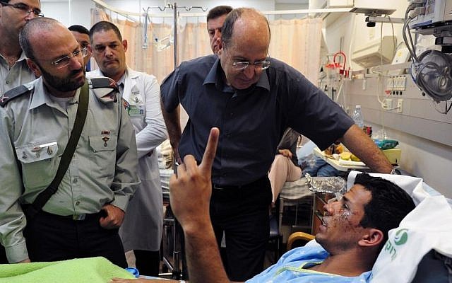 Defense Minister Moshe Ya'alon, center, visiting an IDF soldier on Sunday, November 3, 2013, who was wounded late Thursday, October 31, 2013, in an explosion while attempting to destroy a Hamas tunnel intended to facilitate terror attack in Israeli towns along the Gaza border. (photo credit: Ariel Hermoni, Defense Ministry) Defense Minister Moshe Ya'alon, center, visiting an IDF soldier on Sunday, November 3, 2013, who was wounded late Thursday, October 31, 2013, in an explosion while attempting to destroy a Hamas tunnel intended to facilitate terror attack in Israeli towns along the Gaza border. (photo credit: Ariel Hermoni, Defense Ministry)