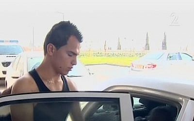 Palestinian Hussein Rawarda, 16, who stabbed IDF soldier Eden Atias on a bus in Afula on Wednesday, November 13, 2013, is led away by police. (Screenshot: Channel 2)