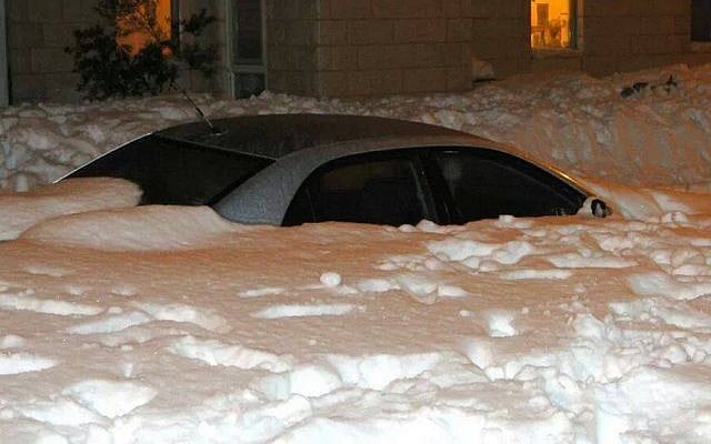 A snow-covered car in the settlement of Neve Daniel, just south of Jerusalem, Saturday night, December 14, 2013 (photo credit: Laura Ben-David)