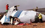 Police and investigators look at what remains of the flight deck of Pan Am 103 in a field in Lockerbie, Scotland, December 22, 1988. (photo credit: AP)