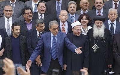 Amr Moussa, center, the chairman of Egypt's 50-member panel tasked with amending Egypt's Islamist-drafted constitution, arranges the members for a group picture after finishing the final draft of a series of constitutional amendments at the Shoura Council in Cairo, Egypt, on Monday, December 2, 2013. (photo credit: AP/Amr Nabil)