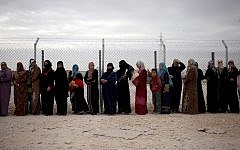 File photo: Syrian refugee women stand in line to receive their family's share of winter aid kits at the Zaatari refugee camp, near the Syrian border. (photo credit: AP/Mohammad Hannon)