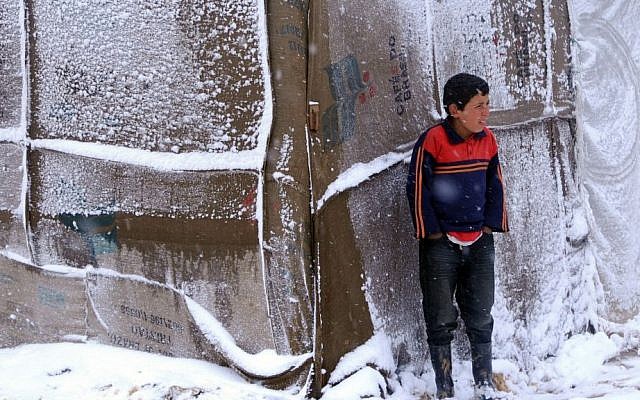 A Syrian refugee boy stands outside his tent as a heavy snowstorm batters the region, in a camp for Syrians who fled their country’s civil war, in the Bekaa valley, eastern Lebanon, Wednesday, Dec. 11, 2013. (photo credit: AP) A Syrian refugee boy stands outside his tent as a heavy snowstorm batters the region, in a camp for Syrians who fled their country’s civil war, in the Bekaa valley, eastern Lebanon, Wednesday, Dec. 11, 2013. (photo credit: AP)
