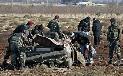 Lebanese army investigators inspect at the scene where a car bomb went off next to a Hezbollah base near the village of Sbouba in the Baalbek region pg eastern Lebanon, early Tuesday, December 17, 2013. (photo credit: AP Photo/Bilal Hussein)