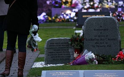 A member of the public looks on at a memorial stone in memory of the victims of the Pan Am flight 103 bombing in the garden of remembrance at Dryfesdale Cemetery, near Lockerbie, Scotland, Saturday, Dec. 21, 2013. (Photo credit: AP/Scott Heppell)