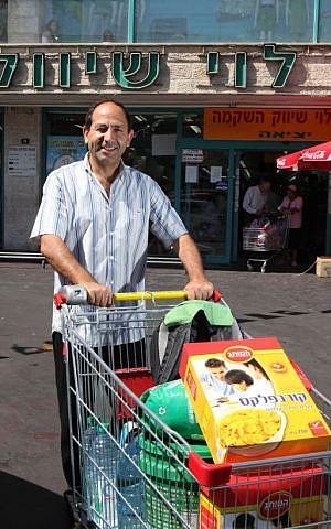 Rami Levy wheeling a full cart outside one of his stores (photo credit: Yossi Zamir/Flash 90)