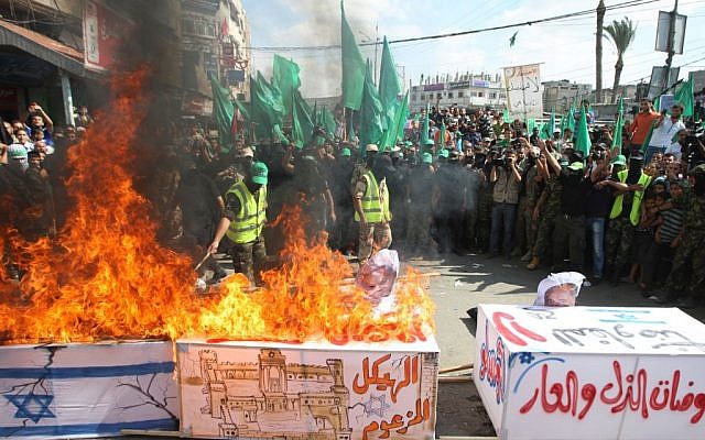 Hamas activists burn a coffin draped in an Israeli flag, during a rally marking the 13th anniversary of the so-called Al-Aqsa uprising or Second Intifada, in the refugee camp of Nusairat, central Gaza Strip, Sept. 27 2013 (photo credit: Abed Rahim Khatib/Flash90) Hamas activists burn a coffin draped in an Israeli flag, during a rally marking the 13th anniversary of the so-called Al-Aqsa uprising or Second Intifada, in the refugee camp of Nusairat, central Gaza Strip, Sept. 27 2013 (photo credit: Abed Rahim Khatib/Flash90)