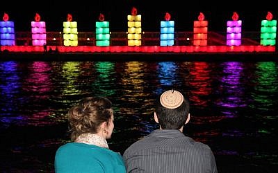 A couple observes a menorah floating off the Tel Aviv Port on November 25, 2013. (photo credit: Gideon Markowicz/Flash90)
