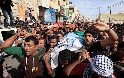 Mourners attend the funeral of Palestinian militants Khaled al-Najjar and Mussa Fanasheh on November 27, 2013 in the West Bank village of Yatta, one day after they were shot dead, along with another Palestinian activist (photo credit: Issam Rimawi/Flash90)