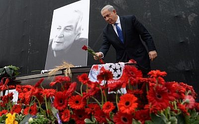 Prime Minister Benjamin Netanyahu lays a flower on the coffin of Israeli legendary singer Arik Einstein (photo credit: Kobi Gideon/GPO/FLASH90)