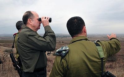 Defense Minister Moshe Ya'alon looks into Syrian territory from the Golan Heights on December 3, 2013. (Photo credit: Ariel Hermoni/Ministry of Defense/Flash 90)