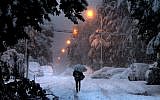 Walking in a winter holy land. A man walks down a snowy street in Jerusalem on Thursday evening (photo credit: Hadas Parush/Flash 90)