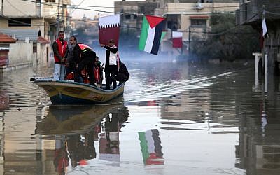 Palestinians take a boat through flooded streets in Gaza City, December 17, 2013 (photo credit: Wissam Nassar/Flash90)