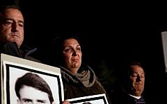 Israelis, some of whom have lost relatives to Palestinian terrorism, hold aloft placards and pictures of terror victims during a protest against the upcoming release of Palestinian prisoners, outside the prime minister's residence in Jerusalem, Saturday, December 28, 2013 (photo credit: Hadas Parushl/Flash90)