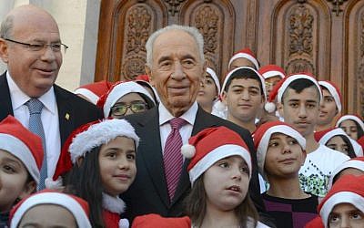 President Shimon Peres, center, with Christian schoolchildren in Ramle, on December 22, 2013 (photo credit: Mark Neiman/GPO)